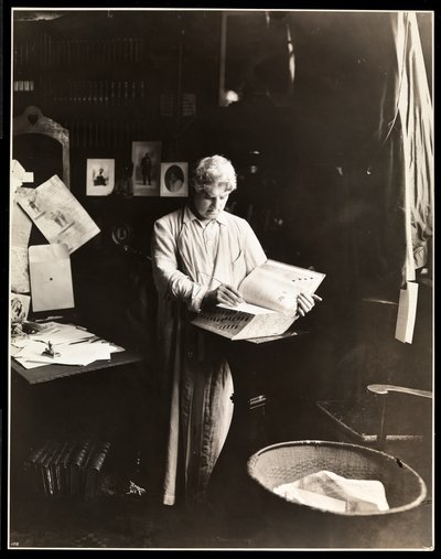 David Belasco standing holding a dictionary, after 1909 by Byron Company